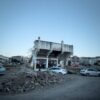 Demolished building amidst debris with parked cars, seen in Ordu, Türkiye.
