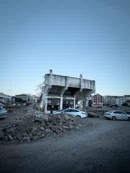Demolished building amidst debris with parked cars, seen in Ordu, Türkiye.