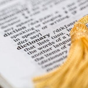 Close-up image of a dictionary page focused on the word 'dictionary' with a yellow tassel.