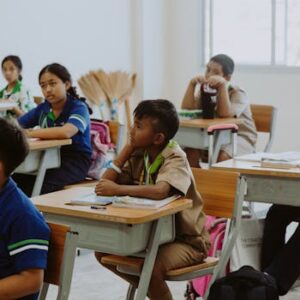 Children attentively listening in a classroom setting, focused on learning and education.