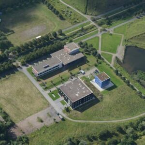 A stunning aerial photograph showcasing a modern educational campus with green landscapes and pathways, captured from above.
