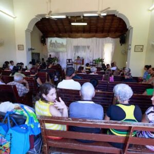 A diverse group of people gathered inside a chapel for a community event.