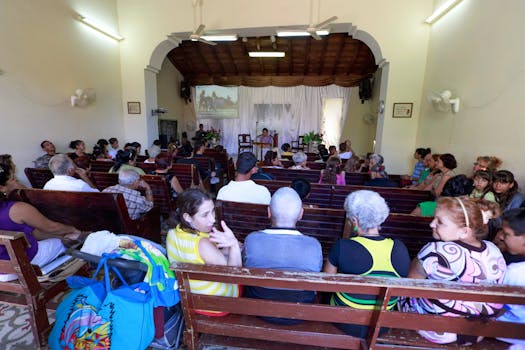 A diverse group of people gathered inside a chapel for a community event.