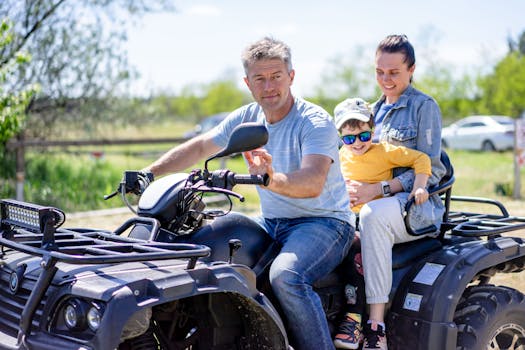 Father, mother, and child enjoying a fun ATV ride outdoors on a sunny day.