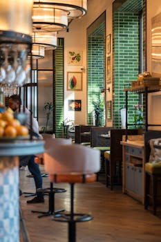 Elegant restaurant interior featuring a modern design with green tiles and stylish seating.
