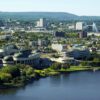 Aerial cityscape of Ottawa and Gatineau with modern architecture and lush greenery.
