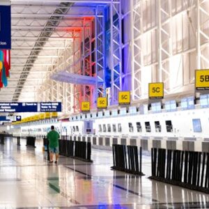 Wide view of Chicago airport terminal showcasing architecture and check-in counters. Flags and signages add vibrant detail.