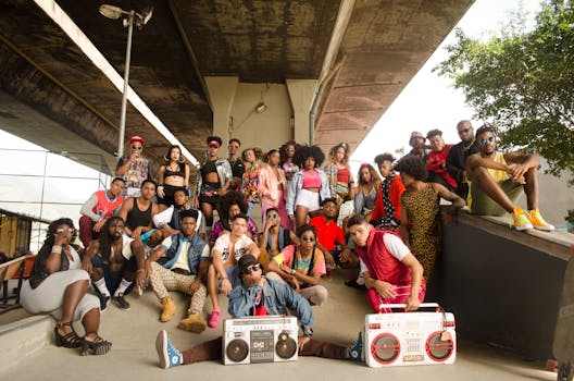 Energetic group posing stylishly under an urban bridge with boomboxes, featuring diverse fashion and expressions.
