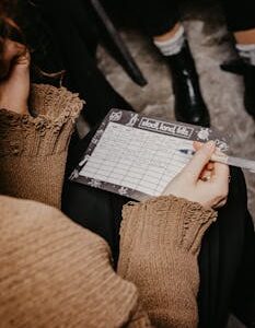 A woman writing on a paper playing a word game during a social gathering.