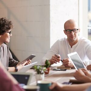 Group of professionals engaged in a brainstorming session around a table in a contemporary office space.