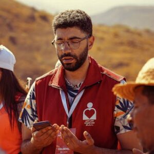Volunteers gathered outdoors for a community meeting, promoting teamwork and collaboration.