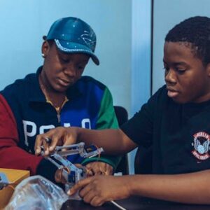Two students assembling a robot in a hands-on STEM workshop in Accra, Ghana.