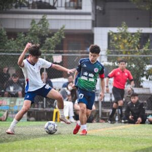 Intense football match in Hà Nội, showcasing dynamic play and teamwork on a vibrant turf field.