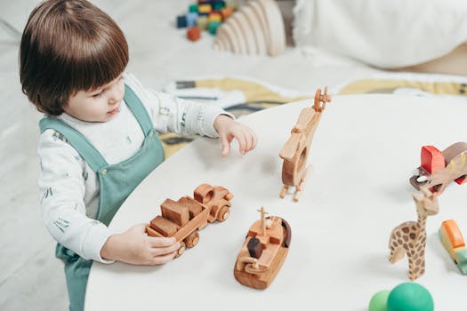 A young child playing with wooden toys at a round table in a bright playroom.