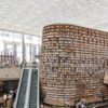 Interior view of a modern library in Seoul with a vast bookshelf and escalators under a glass ceiling.