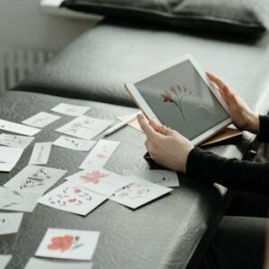Artist finalizing floral tattoo designs on a digital tablet in a studio setting.