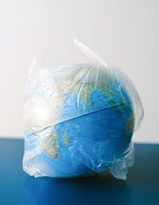 A globe encased in a plastic bag symbolizing environmental issues, recycling, and pollution.