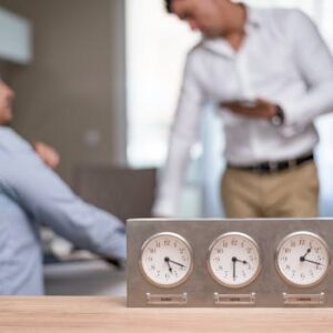 Two businessmen in an office with clocks displaying Dubai, Sofia, London time.
