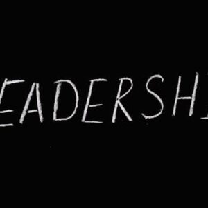 Chalk text spelling 'Leadership' on a blackboard, symbolizing guidance and authority.
