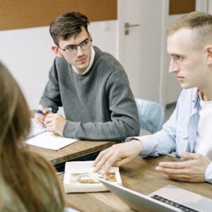 Three young professionals engaged in a focused group discussion at a modern office setting.
