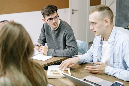 Three young professionals engaged in a focused group discussion at a modern office setting.