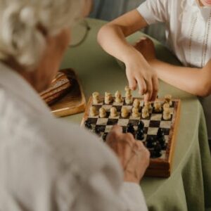 A close-up of hands playing chess, highlighting family bonding and strategic gameplay in a cozy home environment.