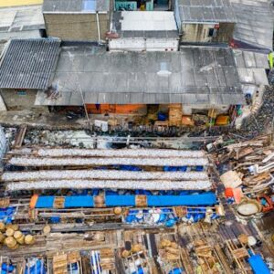 Aerial view of a densely packed urban settlement in Jakarta, Indonesia, depicting housing and waste.