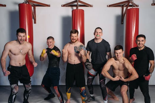 Six muscular men posing confidently in a gym, showcasing fighting spirit and camaraderie.