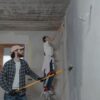 A couple painting a room together, highlighting teamwork in home renovation.
