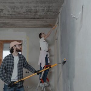 A couple painting a room together, highlighting teamwork in home renovation.