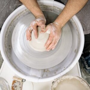 Hands shaping clay on a pottery wheel, emphasizing craftsmanship and artistry.