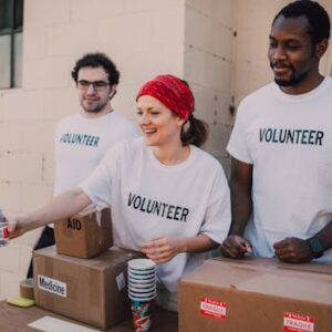 Volunteers distributing aid at an outdoor donation center, promoting social impact and diversity.