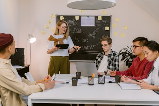 A diverse group of young professionals collaborating in a modern office setting with laptops and notes.