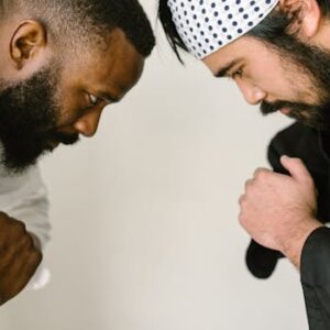 Two martial artists in traditional attire bowing in a moment of respect and focus.