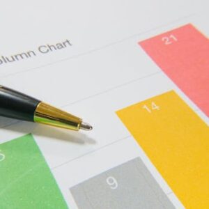 Close-up image of a colorful column chart and pen symbolizing financial analysis.