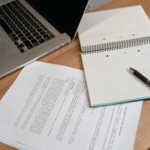 A professional workspace featuring a laptop, documents, and a notepad for productive work.