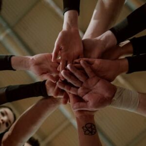 Group of people in a huddle showing unity and teamwork.