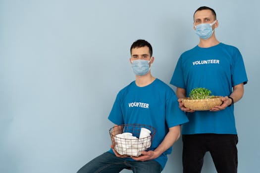 Two volunteers wearing masks holding supplies and plants, promoting charity and environmental protection.
