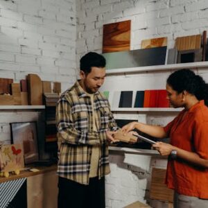 A man and woman discussing samples in a contemporary showroom setting.