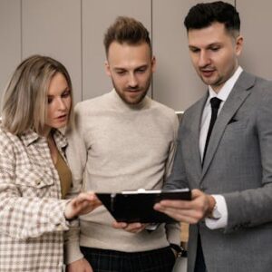 Real estate agent discussing property details with clients indoors.