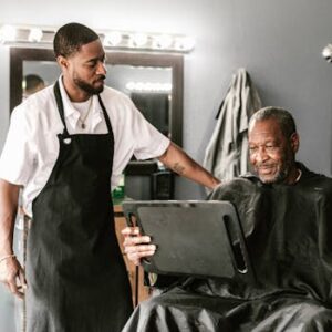 A barber and his client enjoying a moment in a modern barbershop, highlighting friendly service.