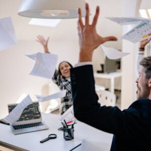 Business team celebrating a successful meeting in a modern office setting, expressing joy.