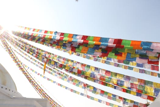 Vibrant prayer flags waving in the breeze against a bright sky in Kathmandu, Nepal.