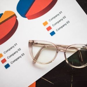Photo of business charts and eyeglasses on a desk, ideal for finance and analytics themes.