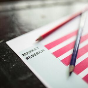 Close-up of market research paper with red graph bars and pencils, emphasizing business analysis.