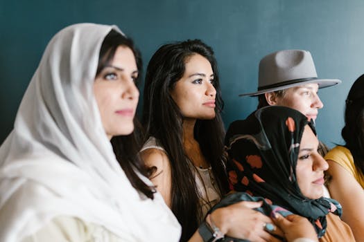Diverse group of women wearing headscarves and hats, captured in an indoor setting.