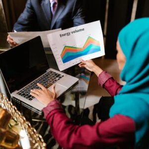 Muslim woman analyzing energy volume data during a business meeting.