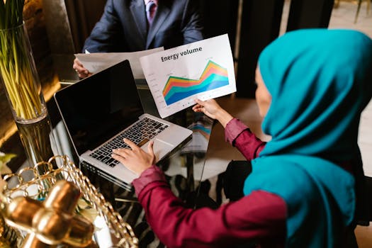Muslim woman analyzing energy volume data during a business meeting.