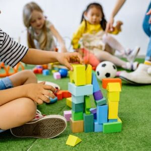 Kids enjoying creative play with wooden blocks at kindergarten, capturing joyful learning.