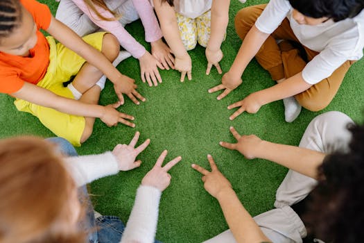 Children sitting in a circle playing fun team games on artificial grass.
